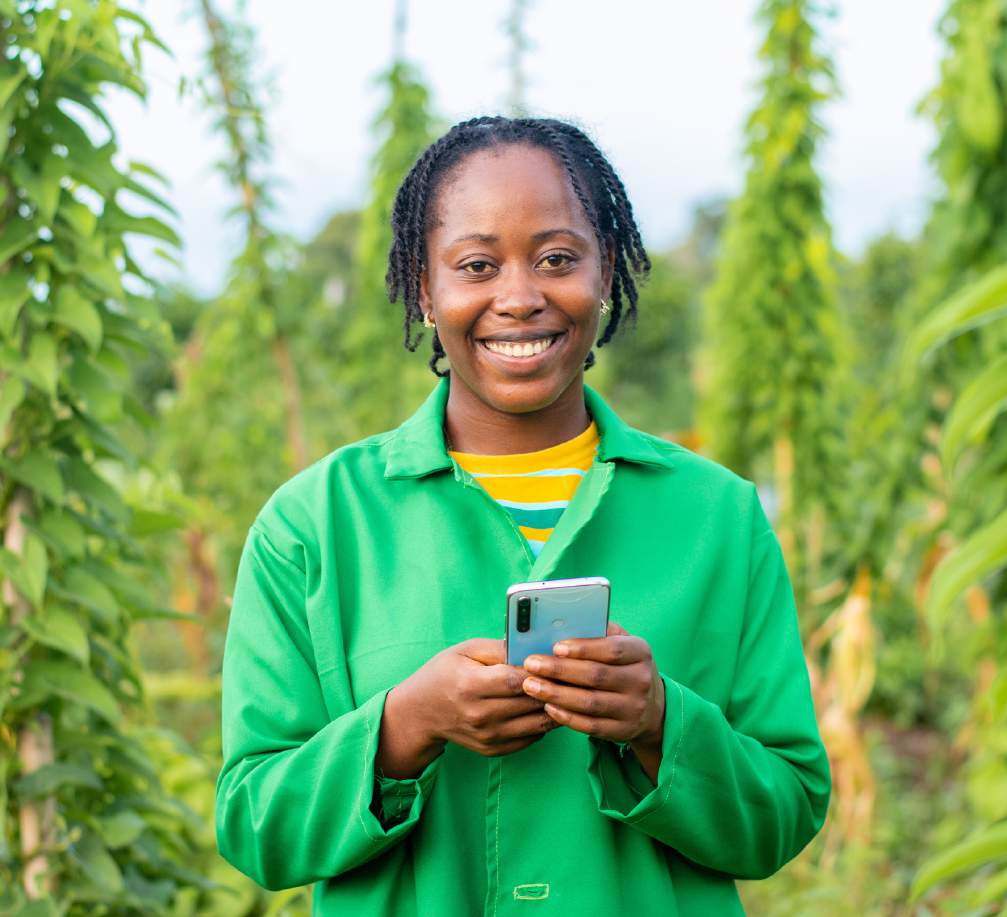 Agricultural worker holding a phone in a crop field